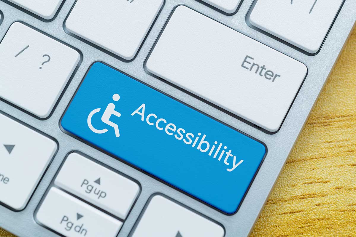 Accessibility Compliance and B2B Risk Keyboard close-up showing a blue accessibility key with a wheelchair symbol, representing digital accessibility and inclusive design.